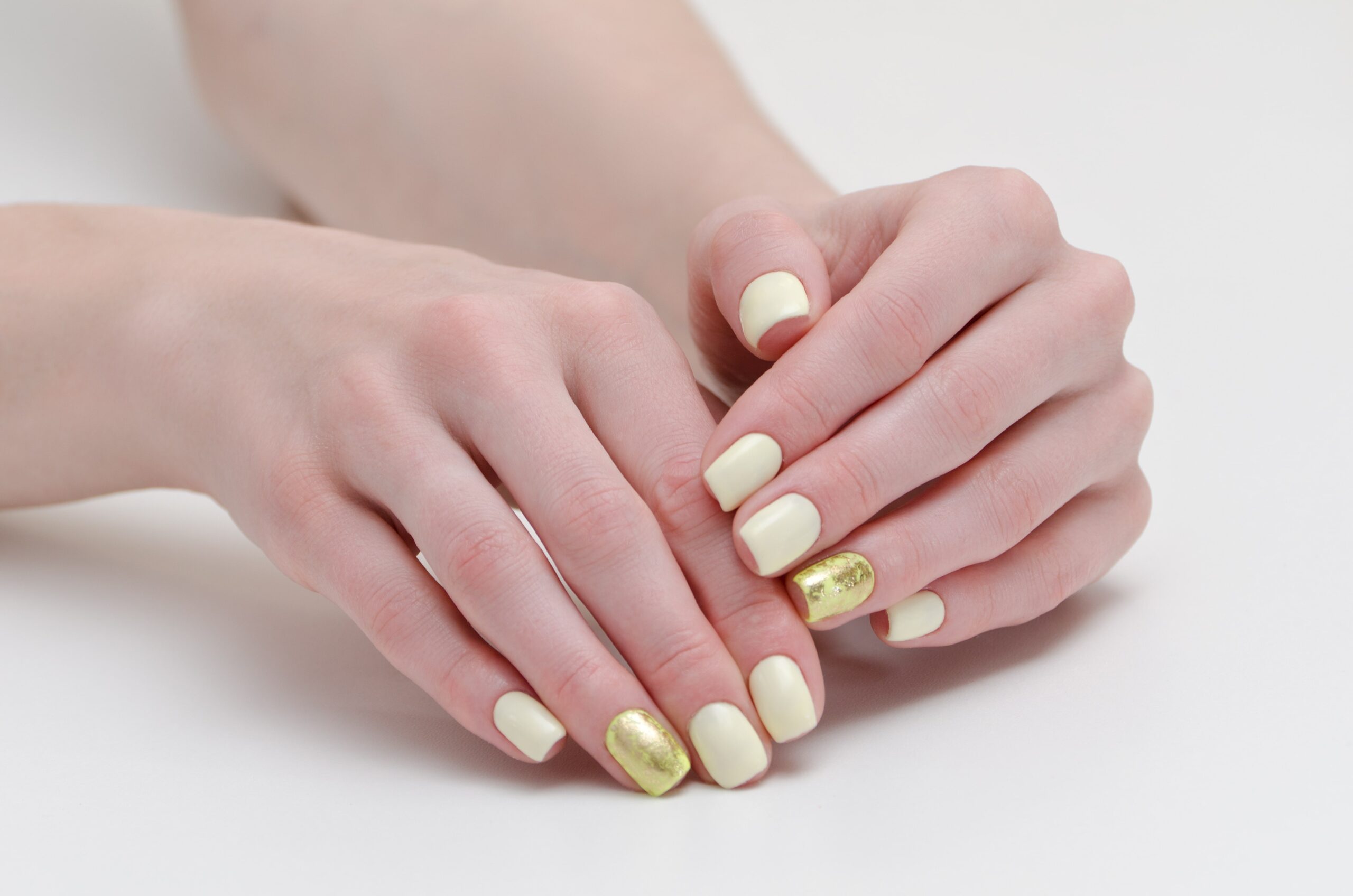 female-hands-with-manicure-yellow-with-gold-covering-nails-min