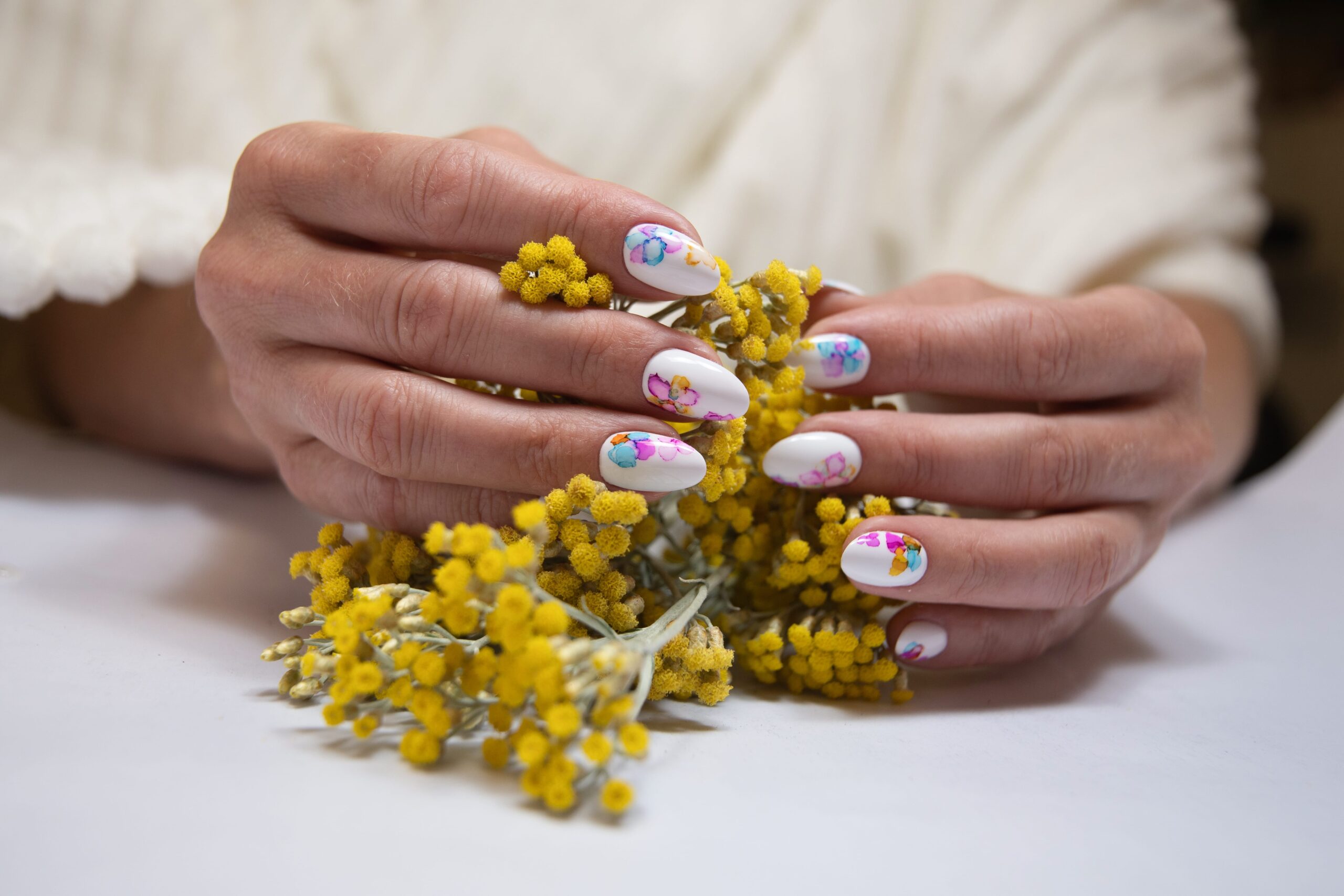 hands-with-beautiful-multi-colored-manicure-hold-bouquet-yellow-flowers (1)-min